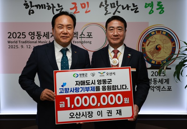 이권재(왼쪽) 오산시장이 고향사랑기부금 100만원을 정영철 군수에게 기탁하고 있다. / 영동군 제공